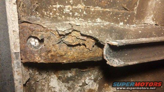 Close-up of heavily rusted metal frame with a bolt visible