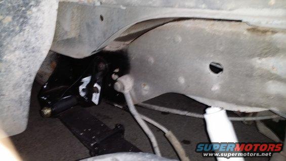 close-up of vehicle's rear suspension with leaf springs and shock absorber visible