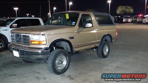 Tan 1996 Ford Bronco parked outside at night