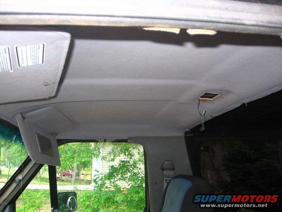 Interior ceiling view showing sun visors and exposed wiring