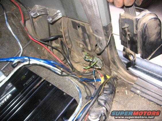 Car interior showing wiring, a Rockford Fosgate amplifier, and seatbelt mechanism