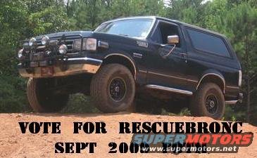 1988 Ford Bronco parked on a dirt incline with trees in the background