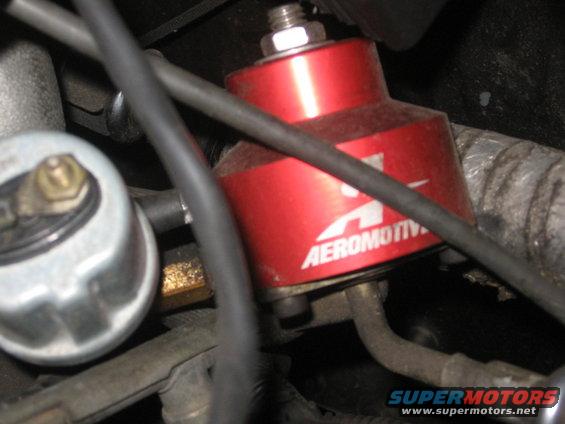 Red Aeromotive fuel pressure regulator with hoses and a silver gauge