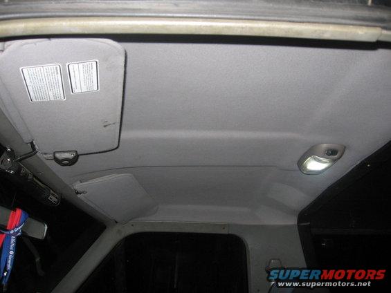 Interior ceiling view showing sun visors and illuminated dome light