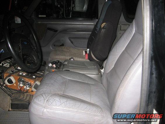 Interior view of a truck or SUV showing the driver's seat, dashboard, and center console. The seats are gray leather