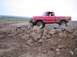 1976 Ford F-100 - A red pickup truck navigates a rocky obstacle course, its off-road capabilities.