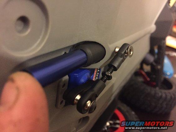 Close-up of an RC car's suspension linkage with a blue shock absorber