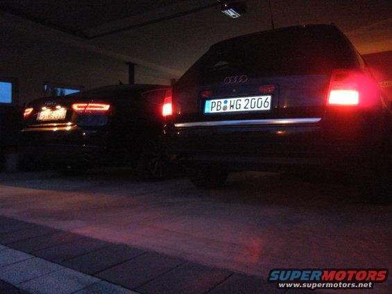 Rear view of two dark sedans, one with license plate PB WG 2006