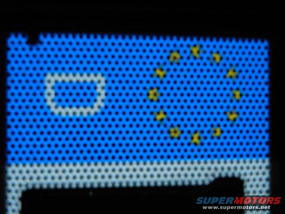 License plate with EU flag and white border, partially obscured by shadow