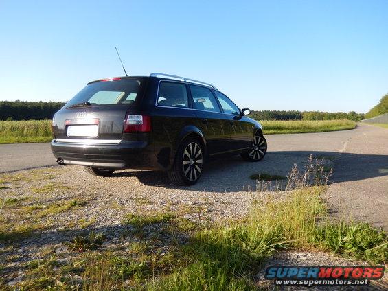 Black 2003 Audi A6 station wagon parked on gravel, rear view