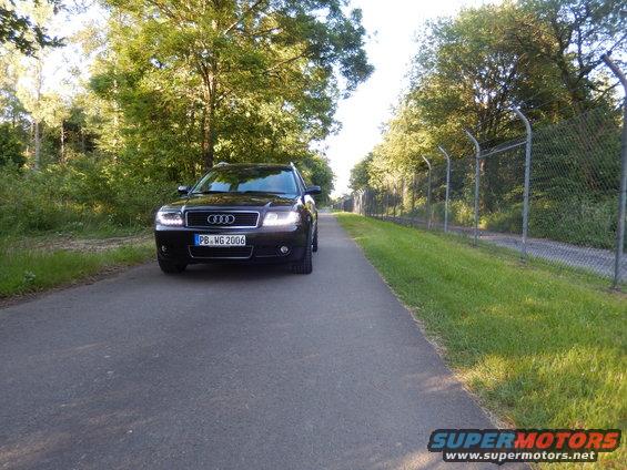 Black Audi A6 wagon parked on asphalt road, front view. License plate PB WG 2006