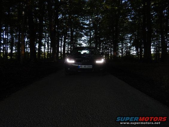 Audi A4 B6 with headlights on, parked on a dark road at night, surrounded by trees. License plate reads PB WG 2006