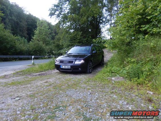 black Audi wagon parked on dirt road next to trees, license plate PB-WG 2004