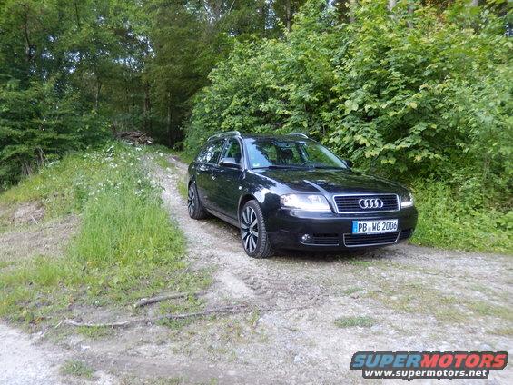Black 2003 Audi A6 Avant parked on a dirt road with trees in the background