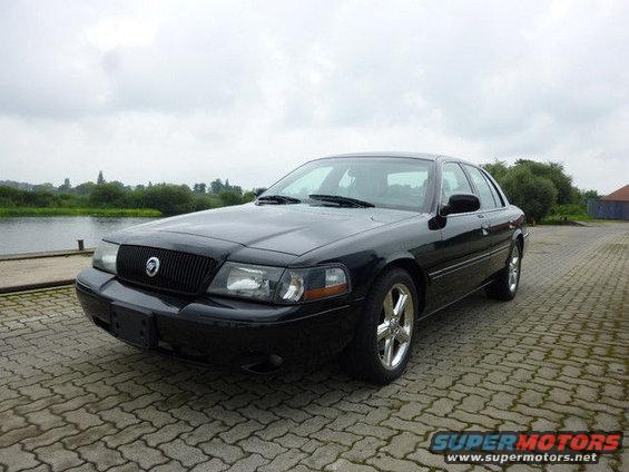 Black 2003 Mercury Marauder parked on cobblestones near water