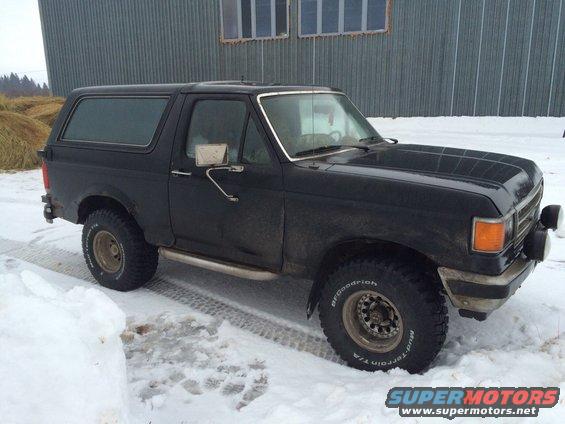 Black 1987 Ford Bronco parked in snow, side view