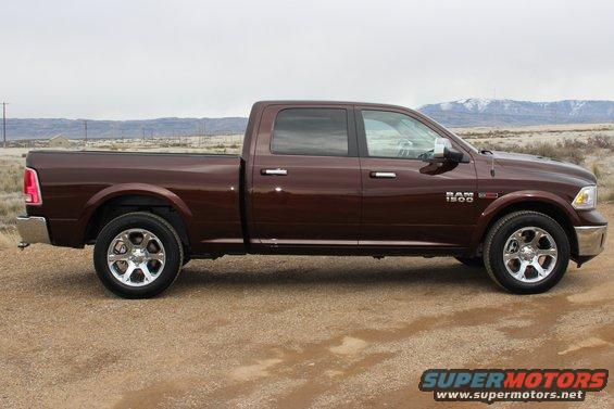 Side view of a brown 2015 Dodge Ram 1500 pickup truck parked on a dirt road
