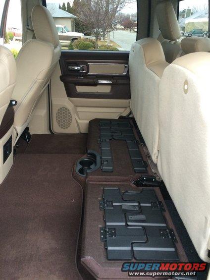 Truck interior with tan seats and brown carpet, showing folded rear seats and door panel