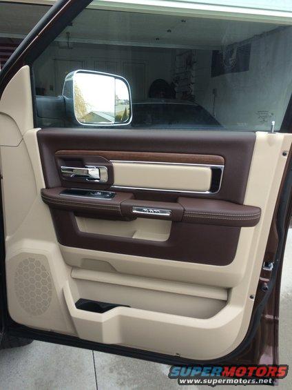 2015 Dodge 1500 interior door panel with brown and tan leather, wood trim, and chrome handle. Ram logo visible