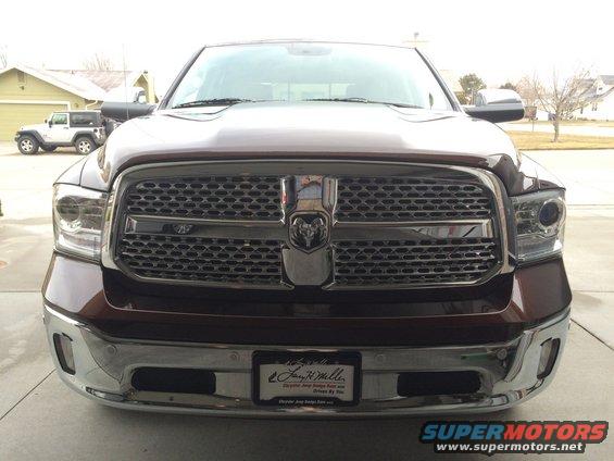 Brown 2015 Dodge 1500 front grille and headlights. Jeep visible in background