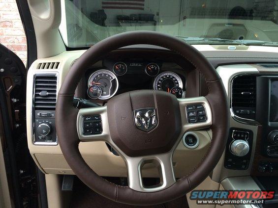 Interior view of a 2015 Dodge 1500 showing the steering wheel, dashboard gauges, and center console