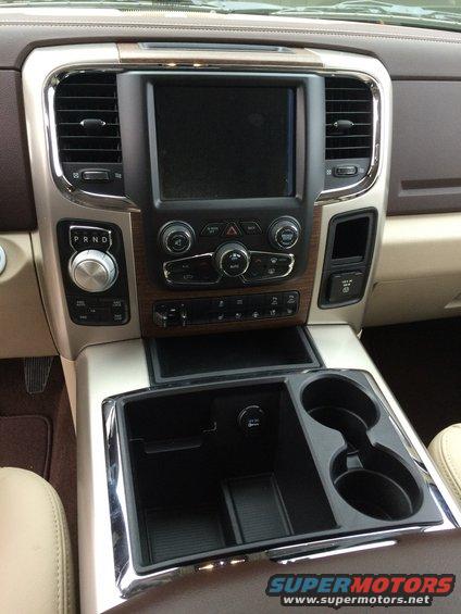 Dashboard of a 2015 Dodge 1500 showing the center console with infotainment screen, climate controls, gear shifter, and cup holders