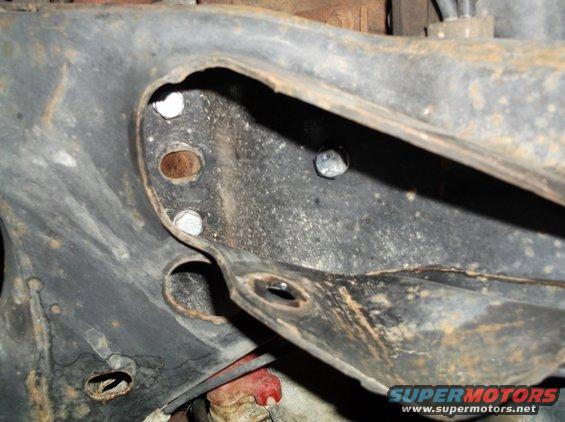 Close-up of a rusty frame section with several bolts