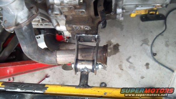 Exhaust pipe connected to engine block with a metal bracket and bolts