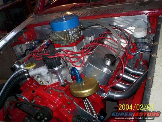 Engine bay with red block, blue air filter, and chrome headers