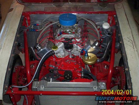 Engine bay with a V8 engine, red frame, and radiator. Date stamp shows 2004