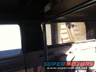 Interior view of a vehicle with a roll cage and tinted windows. A Supermotors logo is visible