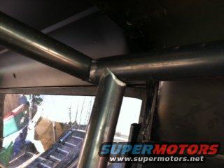 Close-up of metal roll cage tubing joined at an angle inside a vehicle