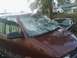 2000 Chevrolet Astro - This maroon van, identified as a 2000 Chevrolet Astro, shows significant damage to its windshield.