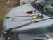 2000 Chevrolet Astro - Windshield wiper mechanism and tools are laid out on the hood of a damaged vehicle.
