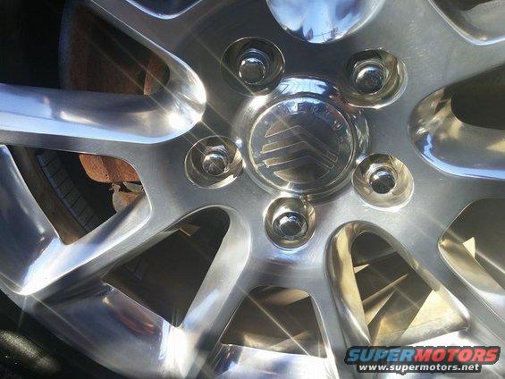 Chrome wheel hubcap with Mercury logo and lug nuts