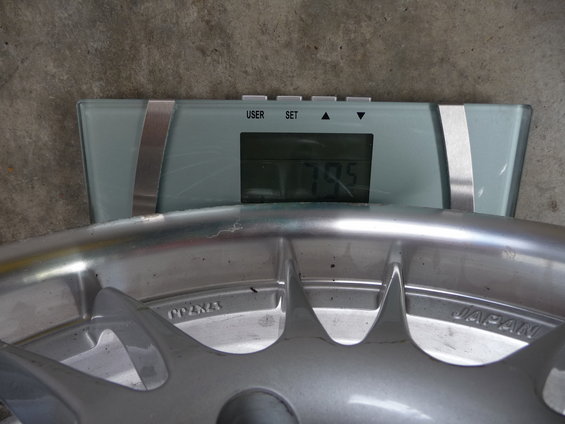 Digital scale showing 79.5 with a car wheel on it. The wheel has 'JAPAN' stamped on it