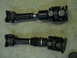 1992 Ford Bronco - Two automotive driveshafts are shown side-by-side on a concrete surface.