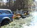 1992 Ford Bronco - A blue 1992 Ford Bronco is partially submerged in swampy water, connected to a custom-built amphibious vehicle.