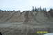 1990 Ford Bronco - An SUV navigates a challenging dirt hill, leaving tire tracks in its wake under an overcast sky.