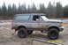 1990 Ford Bronco - Side view of a muddy 1990 Ford Bronco off-road.
