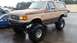 1988 Ford Bronco - This lifted Ford Bronco has a two-tone paint job and aggressive off-road tires.