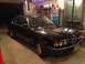 1988 BMW 7 Series - A black 1988 BMW 7 Series sedan is parked indoors, showing its distinctive grille and headlights.