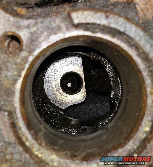 Close-up of engine part with oil and debris