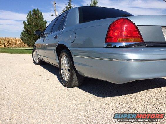 Light blue 2003 Ford Crown Victoria rear quarter view, showing taillight and chrome trim