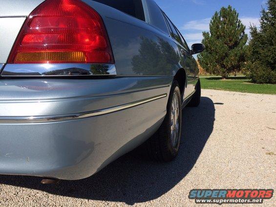 2003 Ford Crown Victoria rear quarter panel, light blue paint, chrome trim, and taillight