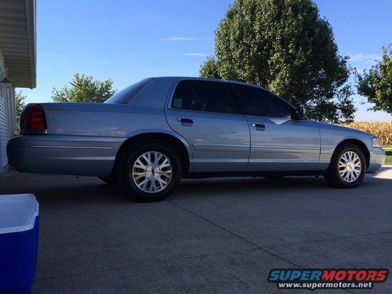 Silver 2003 Ford Crown Victoria parked on concrete, side view