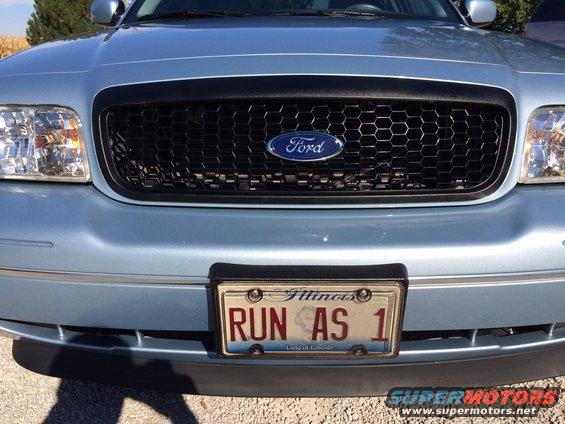 Light blue 2003 Ford Crown Victoria front grille with honeycomb pattern and Illinois license plate 'RUN AS 1'