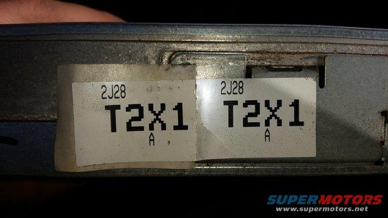 Close-up of two labels on an engine control module, both showing '2J28 T2X1 A'