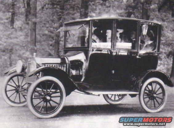 early touring car with enclosed cabin and spoked wheels