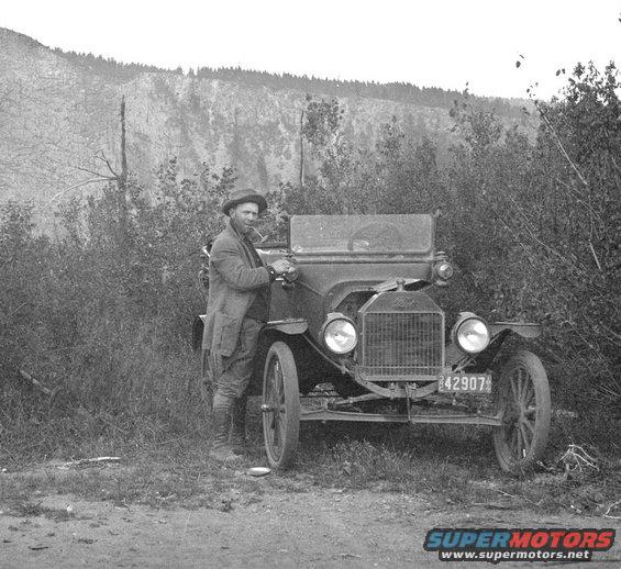 1915 Ford Model T with license plate 42907 and a man smoking a pipe